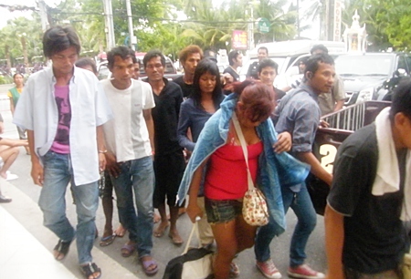 Police bring in the 9 suspects for processing.